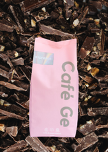 Cargar imagen en el visor de la galería, Bolsa rosa con cafe molido al fondo trozos de chocolate
