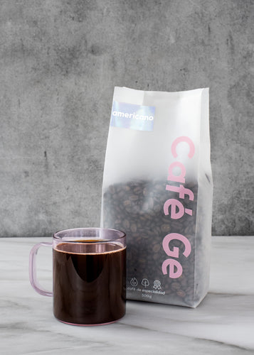 Bosa de cafe americano con taza transparente a lado