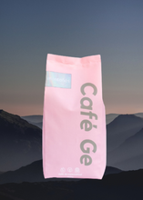 Cargar imagen en el visor de la galería, Bolsa rosa de cafe molido al fondo montanas
