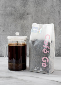 Bolsa de cafe la patrona en grano con prensa francesa a lado