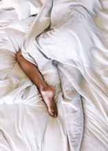 Cargar imagen en el visor de la galería, Persona en una cama con sabanas blancas
